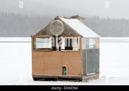 A zerschlagen, behelfsmäßige Eis Angeln Shack in einem Schneesturm. Stockfoto