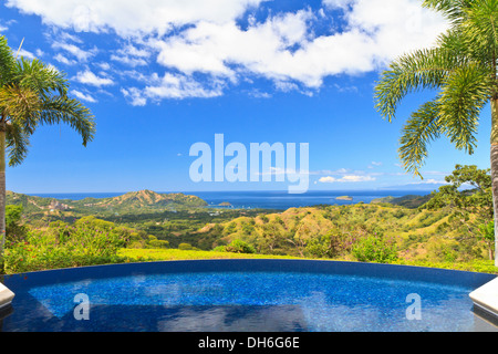 Ein Schwimmbad mit Blick auf den grünen Hügeln von Guanacaste, blicken in Richtung spielen del Coco auf der Pazifikküste von Costa Rica Stockfoto