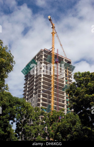 Einen großen und hohen Kran verwendet, um über eine Baustelle auf einer Stadtstraße in Phnom Penh, Kambodscha Wolkenkratzer Türme zu bauen. Stockfoto