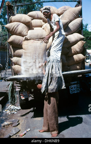 zwei lokale Männer laden, bis ein LKW mit großen Mehlsäcke in Indien Stockfoto