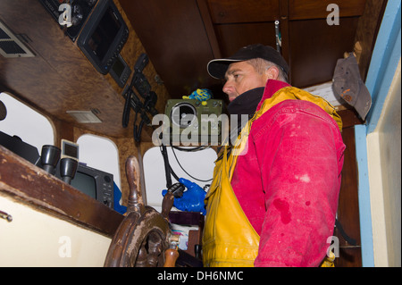 Fischer am Boot Ruder sprechen im radio Stockfoto