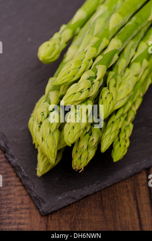 Roher grüner Spargel auf schwarzem Schiefer Stockfoto