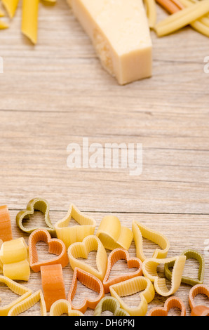 Pasta mit Herzform mit Parmesan auf einem Holzbrett Stockfoto