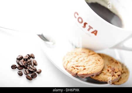 Costa-Kaffee mit Choc Chip Cookies und Kaffee Bohnen auf dem Tisch Stockfoto