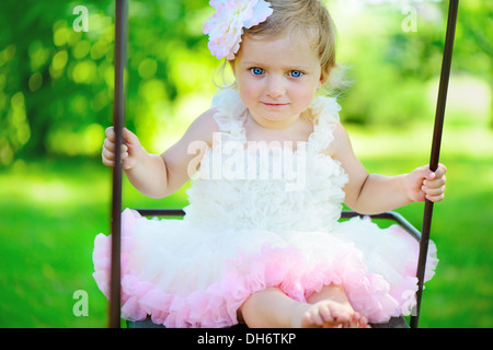 Niedliche kleine Mädchen im Tutu schwingen im park Stockfoto