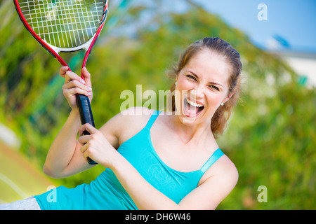 Erfolgreiche Sportlerin mit Schläger auf dem Tennisplatz Stockfoto