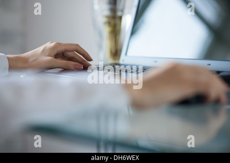 Zarte Frauenhand mit schnurlosen Maus auf Glastisch Stockfoto