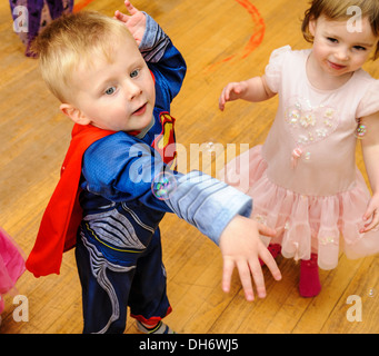 Kinder verkleidet auf einer Halloweenparty Luftblasen fangen Stockfoto