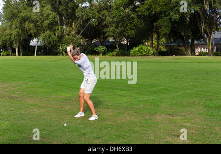 Junge Frau, die einer Aufnahme auf dem Fairway des Golfplatzes im Grenelefe Resort, Haines City, Zentral-Florida, USA Stockfoto