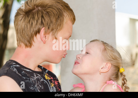 Die erste Liebe und küssen: zwei glückliche niedlichen Kinder treffen Stockfoto