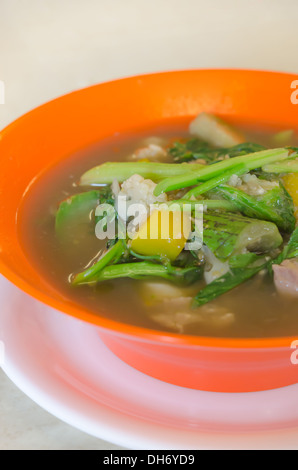 herzhafte dicke Suppe aus Schweinefleisch, Gewürze und Gemüse-Mischung in orange Schüssel, asiatische Suppe Stockfoto