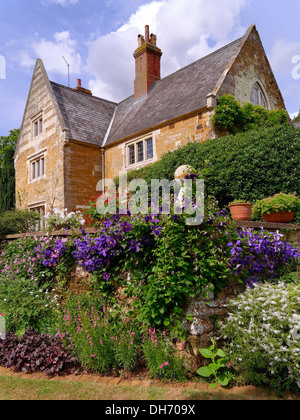 Gärten mit Coton Herrenhaus jenseits, Coton Manor, Coton, Northamptonshire, UK. Stockfoto