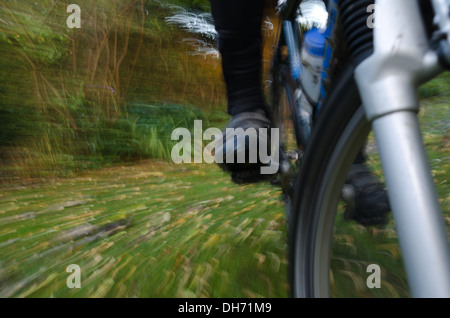 Mountainbiken mit Geschwindigkeit entlang einer schlammigen Langlauf-Route zeigt Detail Rad Fahrer Klemmen Pedale aus einem niedrigen Winkel Stockfoto
