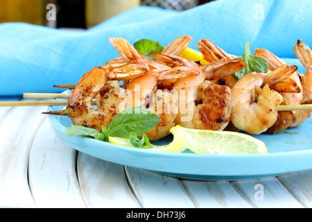 Garnelen vom Grill auf Holzspieße mit Zitrone und Basilikum Stockfoto