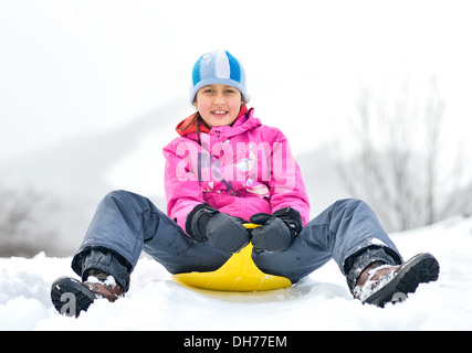 Glückliches Mädchen in Winterkleidung im Schnee Stockfoto