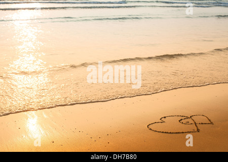 Herzen auf dem Sand des Strandes, weiche Welle des Meeres gezogen Stockfoto