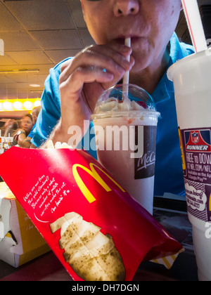 Menschen Essen bei McDonald's Restaurant, Telefon, Pommes Frites und Milkshake Mahlzeit, NYC, USA Stockfoto