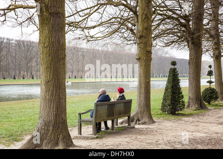 Frauen sitzen auf einer Bank in den Gärten von Versailles, Paris, Frankreich Stockfoto