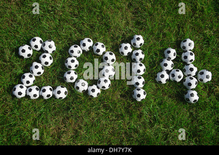 Nachricht für 2014, die mit kleinen Fußball Fußbälle auf dem grünen Rasen Stockfoto