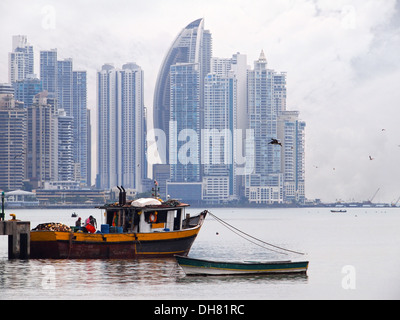 Altes Fischerboot im Vordergrund mit Wolkenkratzern im Hintergrund, Panama City, Panama, Mittelamerika Stockfoto