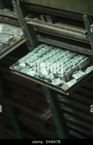 Ein altes Metall Aktenschrank voller antiker industrielle Printpresse Briefmarken. Stockfoto