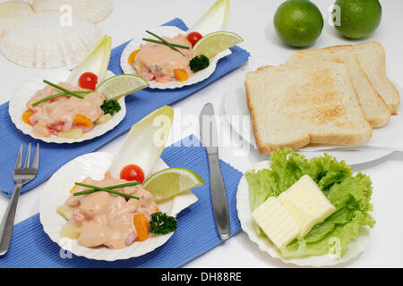 Krabbencocktail in eine Jakobsmuschel, Limetten, Toast, butter Stockfoto