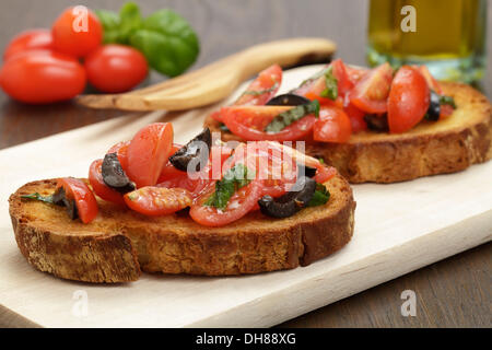 Bruschetta mit Tomaten und schwarzen Oliven Stockfoto