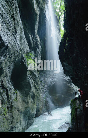 Wanderer, die Beobachtung eines Wasserfalls in die Schlucht Partnachklamm, Reintal, Upper Bavaria, Bavaria, Germany Stockfoto