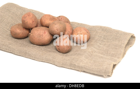 rohen Kartoffeln auf Leinensack isoliert auf weiss Stockfoto