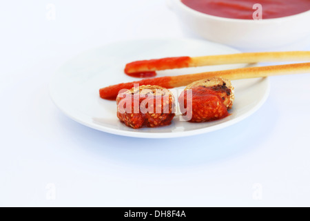 Zwieback mit Sesam, Brot-Sticks und roter Soße auf grauem Hintergrund isoliert. Stockfoto