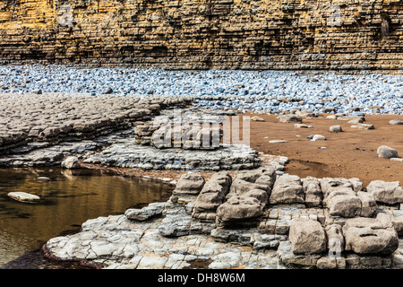 Gesteinsschichten in der Felswand und Strand von Nash Point in Wales. Stockfoto