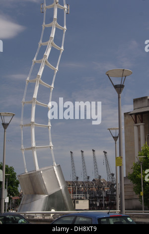 Moderne Skulptur in Millenium Square Bristol mit vier Hafenkräne Hafen im Hintergrund. Stockfoto