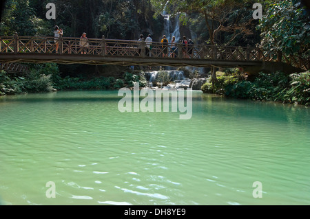 Horizontale Ansicht von Touristen fotografieren von der Brücke über den malerischen Kuang Si Wasserfällen in Laos. Stockfoto