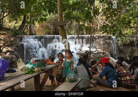 Horizontale Porträt einer asiatischen Familie mit einem Picknick von den malerischen Kuang Si Wasserfällen in Laos.