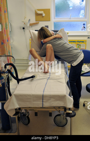 Eine Mutter umarmt ihr trauriges Kind im Krankenhaus Stockfoto