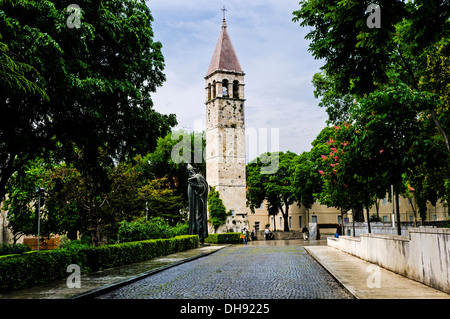 Eine gepflasterten Straße gesäumt von grünen Bäumen auf beiden Seiten und führt zu die monumentale Statue des Bischofs Gregory von Nin, Split Stockfoto