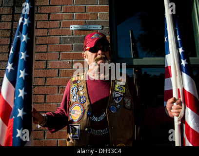 South Carolina Patriot Guard Mitglied hat amerikanische Flaggen außerhalb der gemeinsamen Basis Charleston - Air Base Kapelle während der Trauerfeier im Ruhestand Master Sgt. Dave Williams 30. Oktober 2013. Williams diente als Basis Multimedia-Manager und Chef der inte Stockfoto