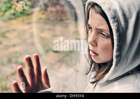 Junge Mädchen Blick aus Fenster Stockfoto