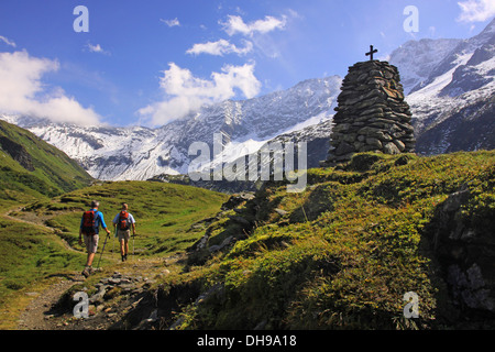 Zwei Bergwanderer zu Fuß auf den Weg zu überqueren, auf Steinsockel in den Bergen von Pinzgau, Salzburgerland, Österreich Stockfoto