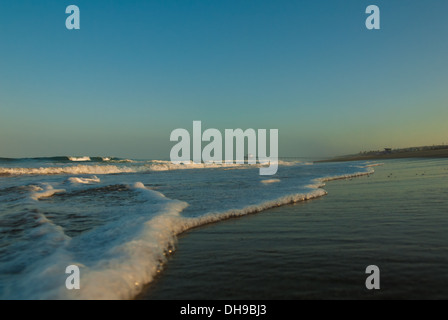 Niedriger Blick auf Manhattan Beach Pier und ankommende Wellen bei Morgenlicht. Manhattan Beach, Kalifornien. (USA) Stockfoto