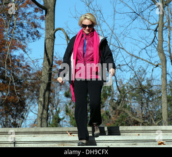 Junge, blonde Frau einige Outdoor-Steinstufen hinunter. Stockfoto