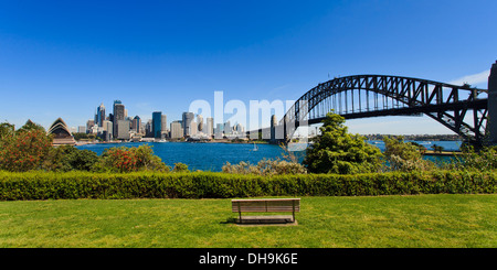 Panoramablick auf Stadt Sydney CBD und Hafen Brücke Wahrzeichen von grünen Park mit Rasen Bank und Blossom Baum sonnigen Sommertag Stockfoto