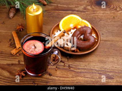 Glühwein in Glas mit Zimtstange, Kerzen und Süßigkeiten, Ansicht von oben Stockfoto