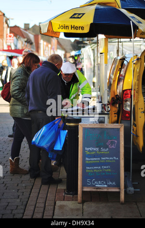 Mittleren gealterten paar Anmeldung zu AA Pannenschutz bei einem Highstreet-stall Stockfoto