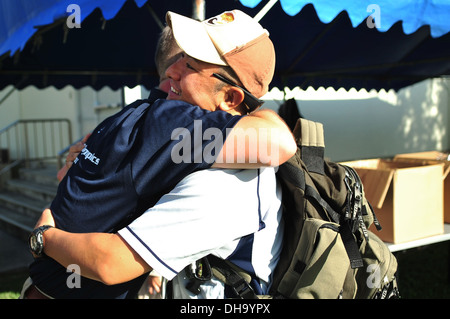 US Air Force Senior Master Sergeant Robert Miller, 909th Aircraft Maintenance Unit Superintendant umarmt techn. Sgt Makoto Mizuguchi, Japan Air Self-Defense medizinischer Technologe von Naha Krankenhaus während der 14. jährlichen Kadena Special Olympics auf Kaden Stockfoto