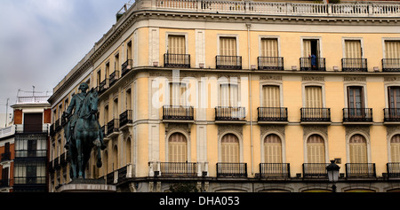 Statue von Carlos III vorne eine typische Fassade in Puerta del Sol Madrid, Spanien Stockfoto