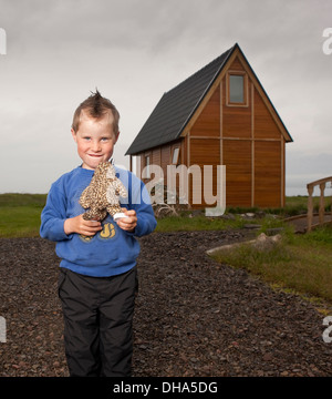 Kleiner Junge hält seine Kuscheltiere, Eskifjordur, Island Stockfoto