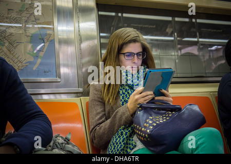 Apple iPad Benutzer liest während ihr mit der u-Bahn in New York auf Montag, 4. November 2013. (© Richard B. Levine) Stockfoto