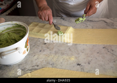 Frau Vorbereitung Ravioli Füllungen von Ricotta und Grüns Stockfoto