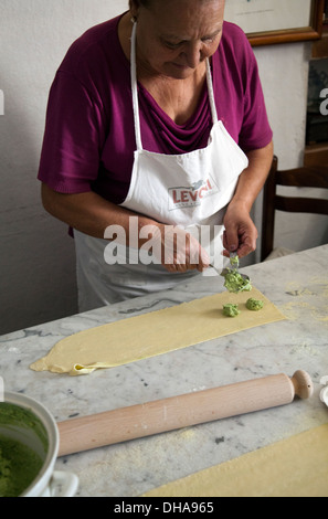 Frau Vorbereitung Ravioli Füllungen von Ricotta und Grüns Stockfoto